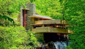 Image of Fallingwater house, a stunning example of organic architecture designed by Frank Lloyd Wright, with a waterfall cascading beneath it.