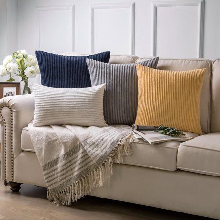 Comfortable couch adorned with colorful throw pillows and a cozy blanket for a budget-friendly decor update.